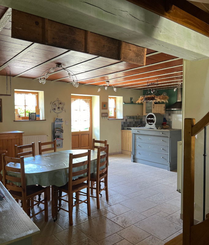La cuisine du gîte avec ses poutres apparentes et sa table ovale